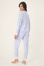 Woman wearing a light blue pajama set with a subtle pattern on a white background